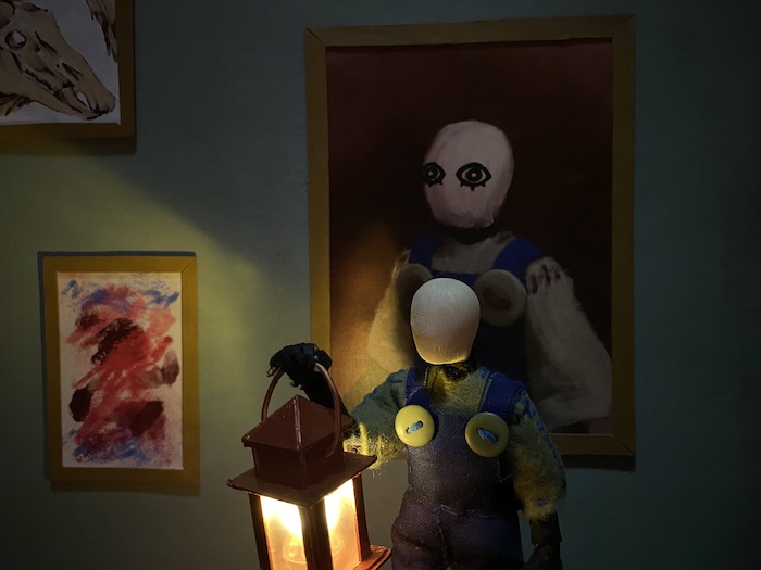 puppet standing in front of similar-looking portrait